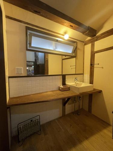 a bathroom with a sink and a mirror at こちの宿 in Yamaga