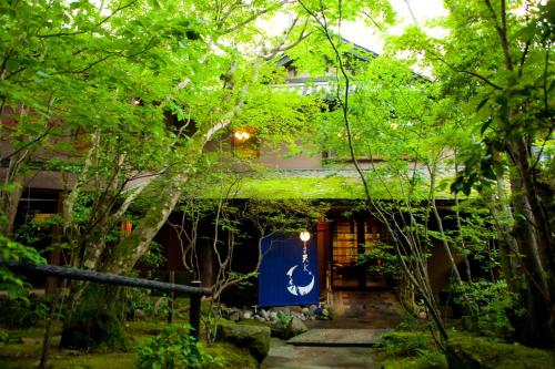 a garden with a blue sign in front of a building at Sanso Tensui in Hita
