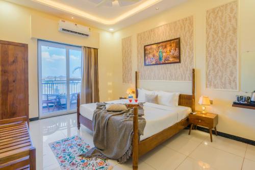 a hotel room with a bed and a balcony at Kamdhenu - Luxurious stay in Udaipur