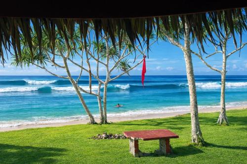 a bench sitting on the beach near the ocean at Leimalo's Bungalow in Port Vila