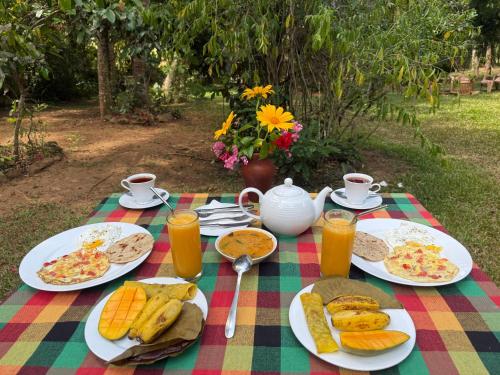 a picnic table with plates of food and orange juice at Brenley B Bungalow in Talalla South