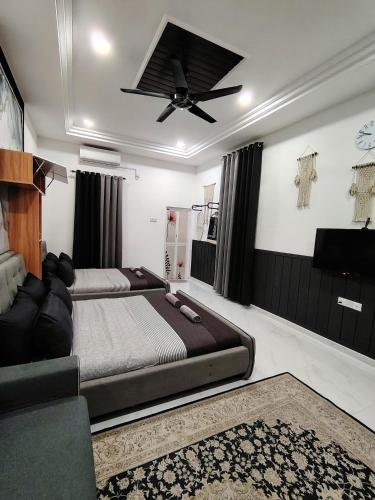 ein Schlafzimmer mit zwei Betten und einem Deckenventilator in der Unterkunft Mini Concept Hotel in Kuala Terengganu