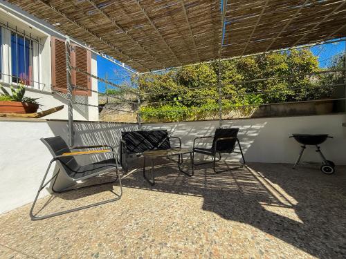 a group of chairs and a table on a patio at Fortuna Garden House in Imperia