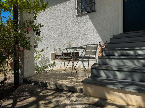 a table and chairs sitting outside of a house at Fortuna Garden House in Imperia