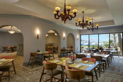 a restaurant with tables and chairs and a chandelier at Marriott El Paso in El Paso