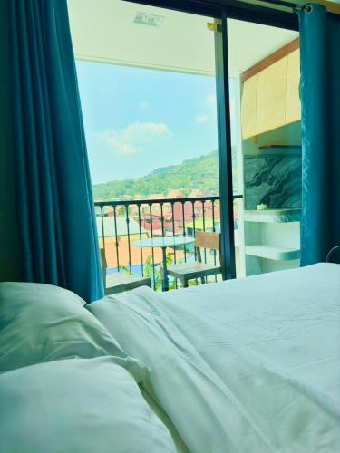 a bedroom with a bed and a balcony with a view at Mersey Residence Koh Samui in Lamai