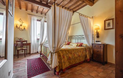 a bedroom with a canopy bed and a table at Hotel La Fonte Del Cerro in Saturnia