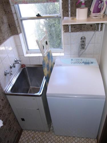 a small kitchen with a sink and a white refrigerator at A Furnished Townhouse in Goulburn in Goulburn