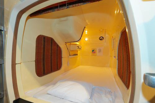 a small room with a bed in the middle at Kawaramachi Gion Onsen Golden Time Takamatsu (Male Only) in Takamatsu