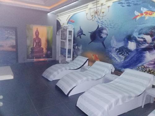 a room with four beds and a wall with an aquarium at Hotel Cems Sunparadise in Alanya