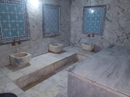 a stone bathroom with three sinks and two windows at Hotel Cems Sunparadise in Alanya