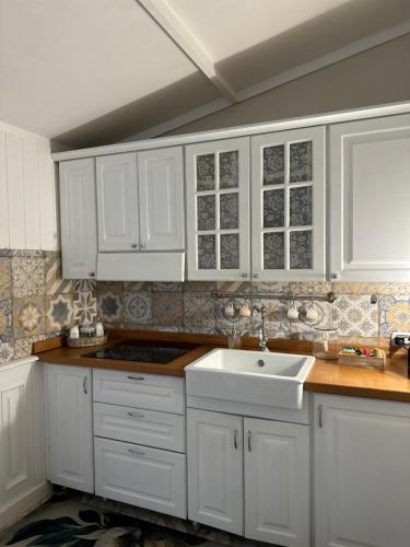 a kitchen with white cabinets and a sink at Il giardino segreto in Taranto