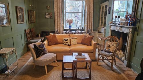 a living room with a couch and a fireplace at Hill House in Bath