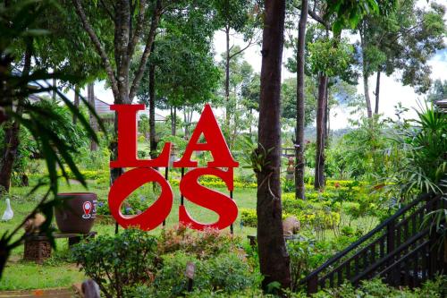 a sign that reads la os in a garden at Sabaidee Valley in Ban Gnik