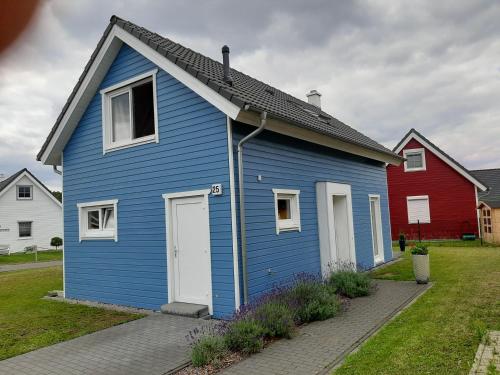a blue house with white doors and a red house at Hus 25 Wandlitz Zerpenschleuse in Wandlitz