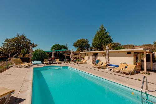 a swimming pool with chairs and a house at Quinta da Estrela in Ponte Nova