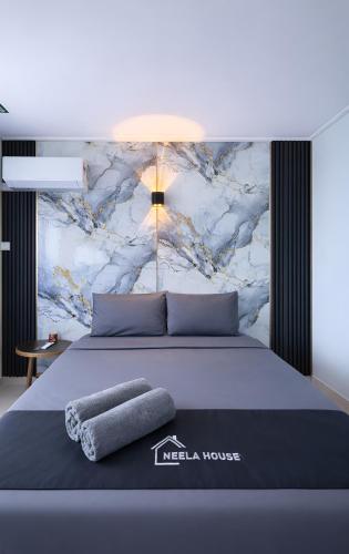 a bedroom with a king sized bed with a marble wall at Neela House in Labuan
