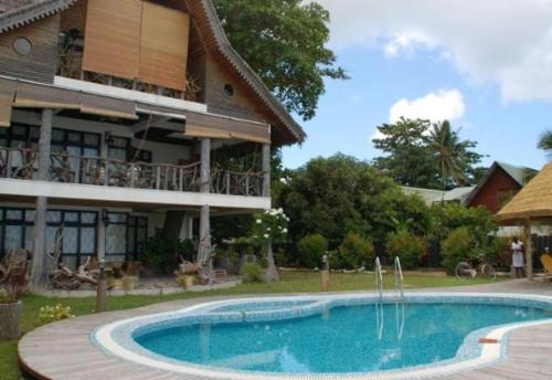 una piscina di fronte a una casa di La Digue Emerald Villa a La Digue