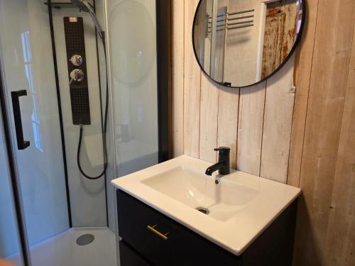 a bathroom with a sink and a shower with a mirror at Norra Vilan - Hagalund in Kopparberg