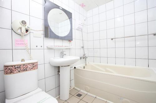 La salle de bains est pourvue d'un lavabo, de toilettes et d'une baignoire. dans l'établissement 享平方文旅, à Touliu