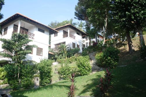 a white house with a garden in front of it at Nongsa Point Marina in Nongsa