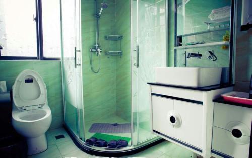 a bathroom with a toilet and a glass shower at Tianmuhu Tianyuege Villa in Liyang