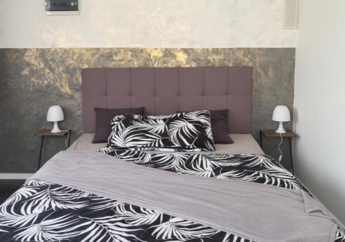 a bed with black and white blankets and pillows at Studio lumineux in La Chaux-de-Fonds