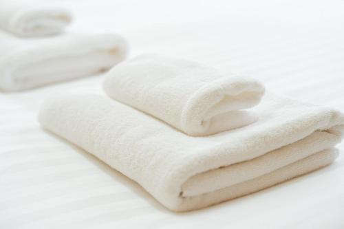 a stack of white towels sitting on a counter at Asahikawa Kawabata House in Asahikawa