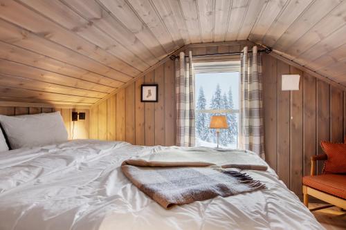 a bedroom with a large white bed with a window at Flott utsikt Peis Elbillader in Aurdal