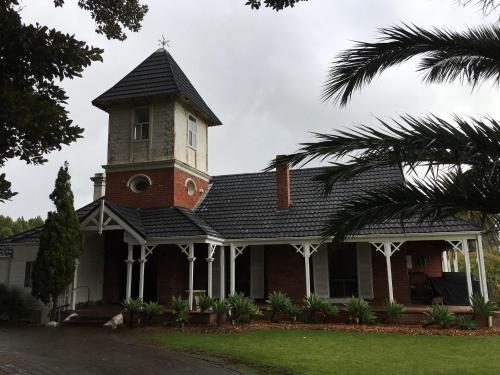 a building with a clock tower on top of it at Ithaca 1896 Manor in Busselton