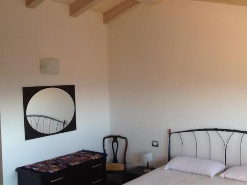 a bedroom with a bed and a mirror on the wall at Villa Susina in Toscolano Maderno