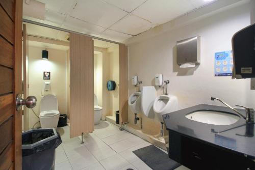 a bathroom with two toilets and a sink and a urinal at MyBed Ratchada in Bangkok