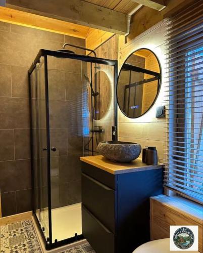 a bathroom with a shower with a sink and a mirror at Chalet Lodge - O'Bord de l'Eau in Gérardmer