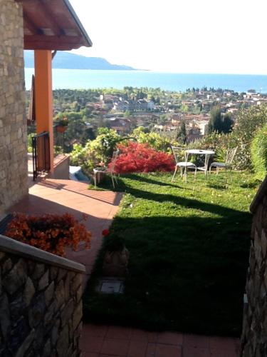 a garden with a table and a view of the city at Villa Susina Casa Vacanze in Toscolano Maderno