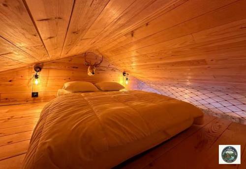 a bedroom with a bed in a wooden room at Chalet Lodge - O'Bord de l'Eau in Gérardmer