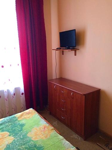 a bedroom with a bed and a dresser with a television at Dream House in Yablunytsya