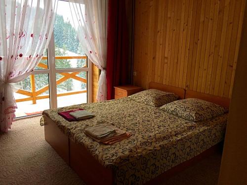 a bedroom with a bed and a large window at Dream House in Yablunytsya