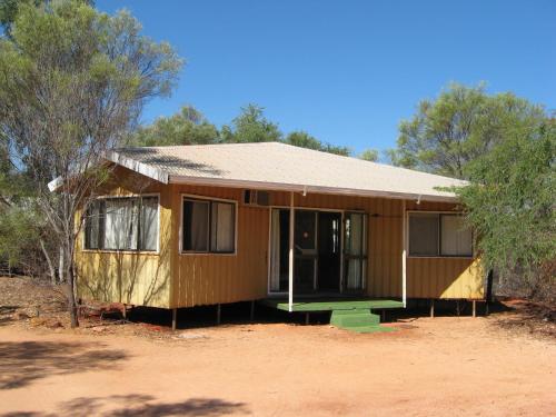 a small house sitting in the middle of a field at Broome Bird Observatory in Broome