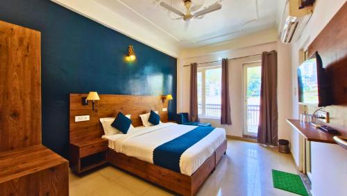 a bedroom with a bed and a blue wall at Haven On Hill - Rishikesh in Rishīkesh