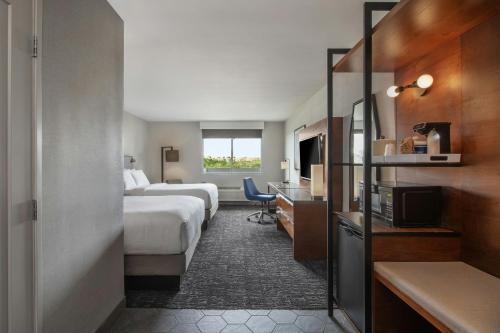 a hotel room with two beds and a desk at Four Points by Sheraton Los Angeles Westside in Los Angeles