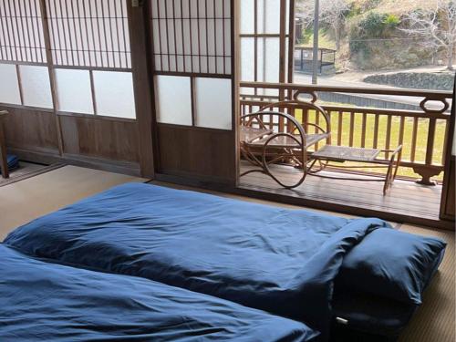 a large bed in a room with a balcony at 名場越庵 -Nabakoshian- in Karatsu