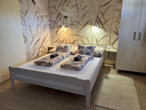 a bedroom with a bed with pillows on it at NAPSUGAR VENDÉGHÁZ in Bogács