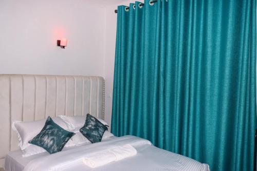a bedroom with a bed with a green curtain at Gessy Homes in Eldoret