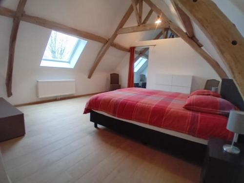 a bedroom with a red bed in an attic at Ferme de la Naverie wi - holiday home for 2 persons in Celles