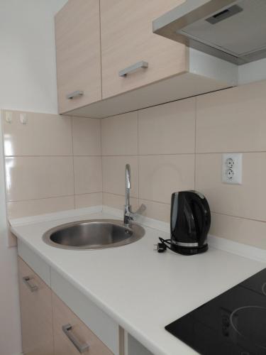 a kitchen counter with a sink and a backpack on it at Apartments and room Maressa Centar in Vodice