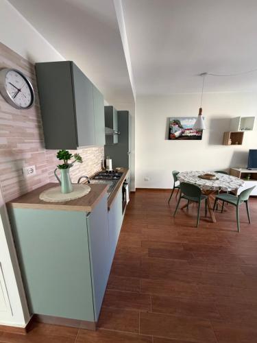 a kitchen with a table and a clock on the wall at Vinaka Etna in Biancavilla