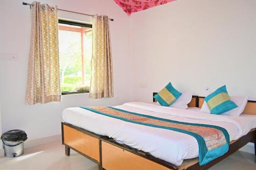 a large bed in a room with a window at Amar Bagh Ranthambore in Khilchipur