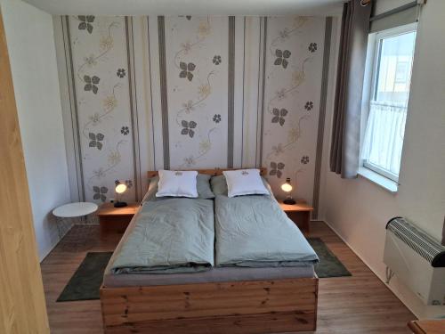 a small bedroom with a bed and two tables at Appartement Ruhe mit zwei Schlafzimmern in Enkirch