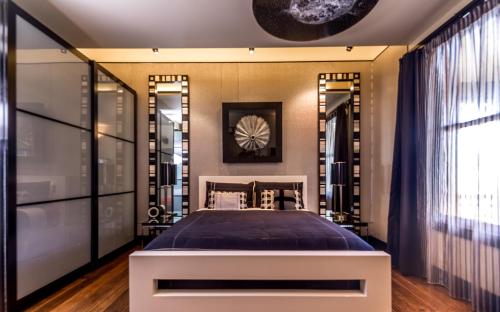a master bedroom with a large bed and mirrors at Corinda Contemporary in Hobart