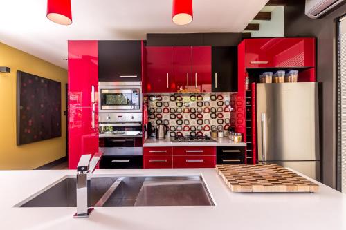 a kitchen with red cabinets and a stainless steel refrigerator at Corinda Contemporary in Hobart